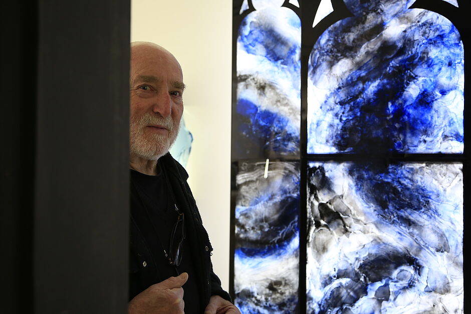 Claude baille maitre verrier devant un de ses vitraux bleu et blanc - Agrandir l'image (fenêtre modale)